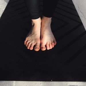 Detail shot of hands and feet placement on a yoga mat.